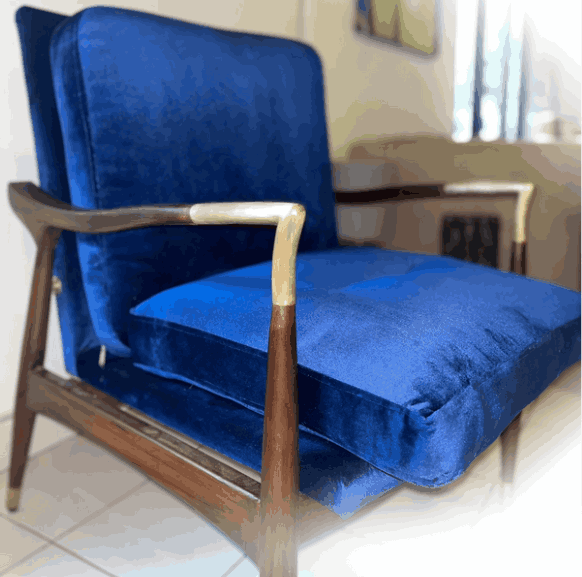 modern armchair with royal blue velvet cushions and wooden frame featuring brass accents